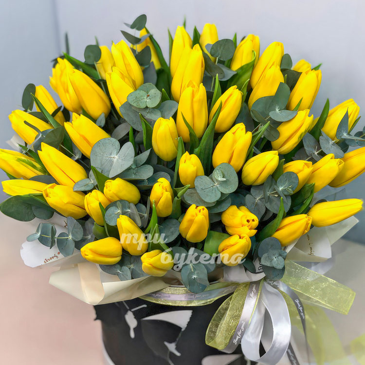 Коробка желтых тюльпанов с эвкалиптом (крупный план)